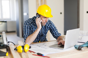 Worker talking on the phone and using laptop