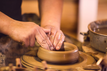 Close-up of hands making pottery on a wheel