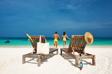 Couple in yellow running on a beach at Maldives