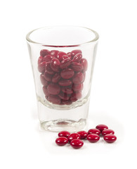 Red pills and pill bottle on white
