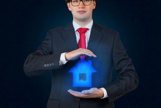 Businessman holding a hologram house icon