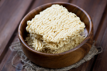 Wooden bowl with dry chinese noodles, horizontal shot