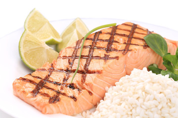 Grilled salmon steak with rice and lime.