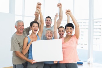 Portrait of happy fit people holding blank board