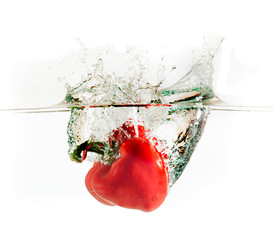 Red pepper in water with splashes on white background