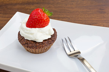 chocolate muffin with whipped cream and strawberry