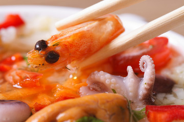to hold an shrimp by means of chopsticks macro