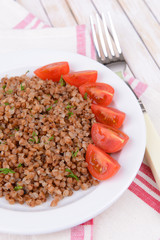 Boiled buckwheat on plate on table close-up
