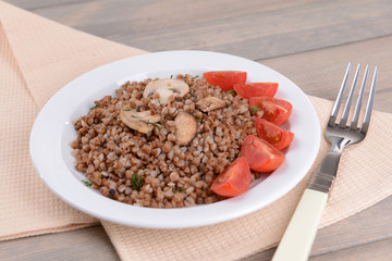 Boiled buckwheat on plate on table close-up