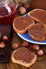 Bread with sweet chocolate hazelnut spread on plate on table