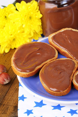 Bread with sweet chocolate hazelnut spread on plate on table