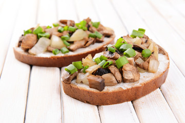 Delicious bruschetta with mushrooms on table close-up