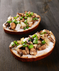 Delicious bruschetta with mushrooms on table close-up