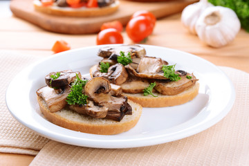 Delicious bruschetta with mushrooms on plate on table close-up