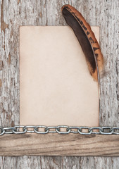 Old paper, feather and metal chain on the old wood