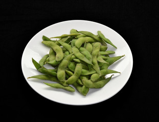 Plato de vainitas en fondo negro.