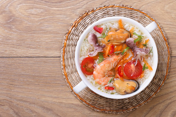 rice soup with seafood on the table close-up top view