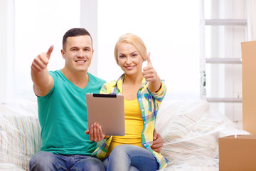 couple relaxing on sofa with tablet pc in new home