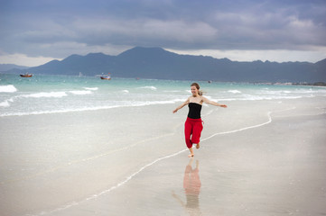 Woman jumping at the beach.