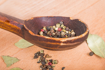 old-fashioned wood spoon with spices and  bay leaves