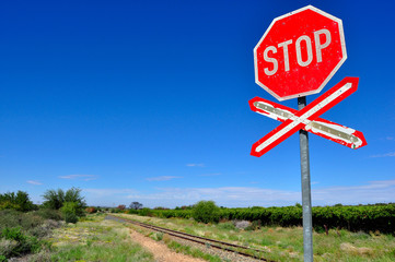 Old stop railway crossing sign against the blue sky