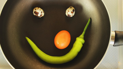 smiley food,  two quail eggs a chicken egg and pepper  in a pan