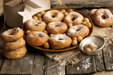 Ceramic plate of sugar donuts  on wooden table