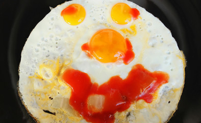 smiley food,  two quail eggs a chicken egg and bacon  in a pan