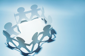 Paper chain team people on blue background holding hands. Copy space