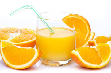 A glass of orange juice with orange quarters
