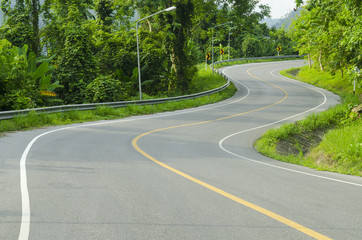 Asphalt road sharp curve along with tropical forest zigzag ahead.