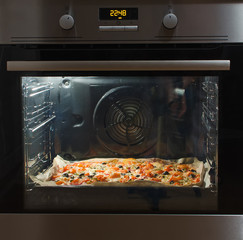 Modern oven with pizza inside.