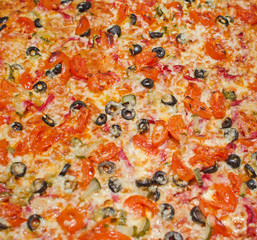 Close-up of pizza with tomato, cheese and olives.