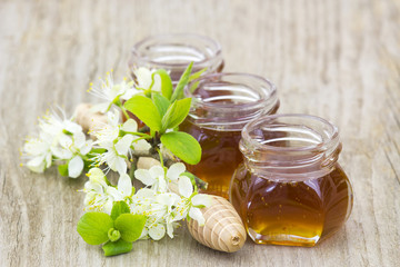 Honey, flowers and honey dipper on wooden background