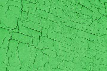 Painted green wall with cracks.