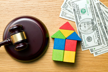 wooden house with money and judge gavel