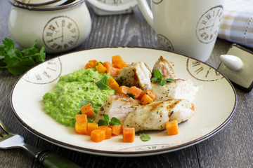 Pieces of chicken with pea puree and pumpkin.