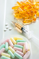 Syringe and colorful pills