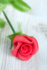 marzipan rose on wooden surface