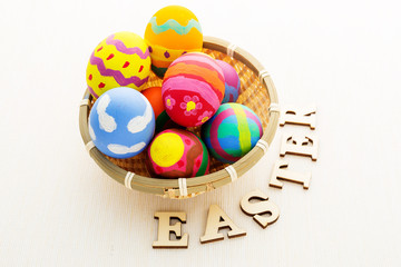 Easter egg in basket with wooden text
