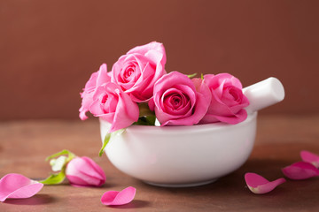 mortar with rose flowers for aromatherapy and spa