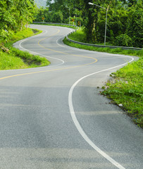 Asphalt road sharp curve along with tropical forest zigzag ahead
