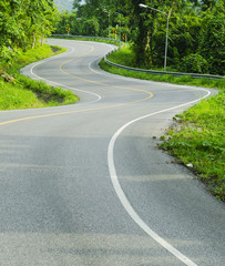 Obraz premium Asphalt road sharp curve along with tropical forest zigzag ahead