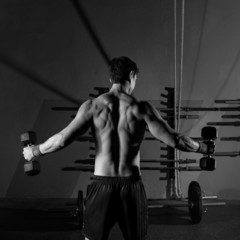 Fototapeta na wymiar hex dumbbells man workout rear view at gym