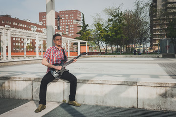 Man in short sleeve shirt playing electric guitar