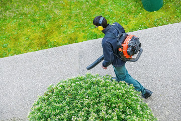 gardener using a gas blower in a park