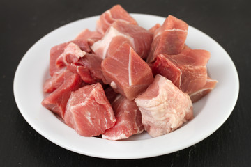 pork on plate on black background