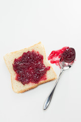 Slice of toast with cherry jam and spoon