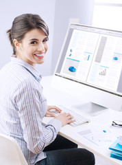 Cute businesswoman smiling at desk