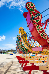 Brightly coloured swing boats on the beach